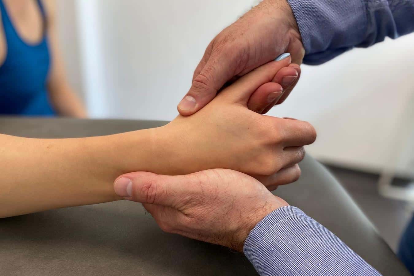 Lekarz ortopeda przeprowadza badanie kliniczne ręki u pacjentki z chorobą de Quervaina w CRS Clinic Warszawa