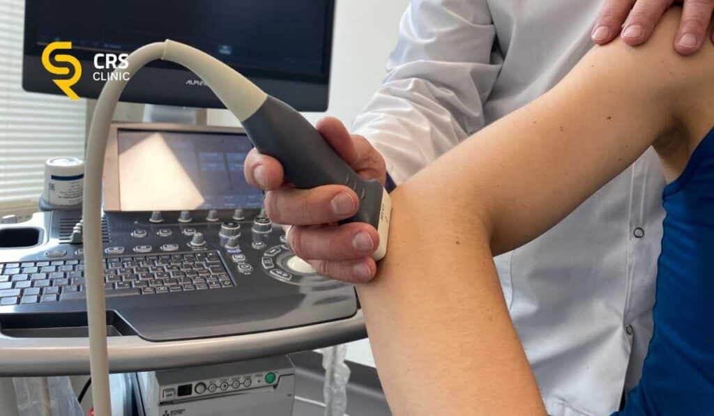 Lekarz ortopeda przeprowadza badanie ultrasonograficzne u pacjentki z bólem łokcia w CRS Clinic Warszawa