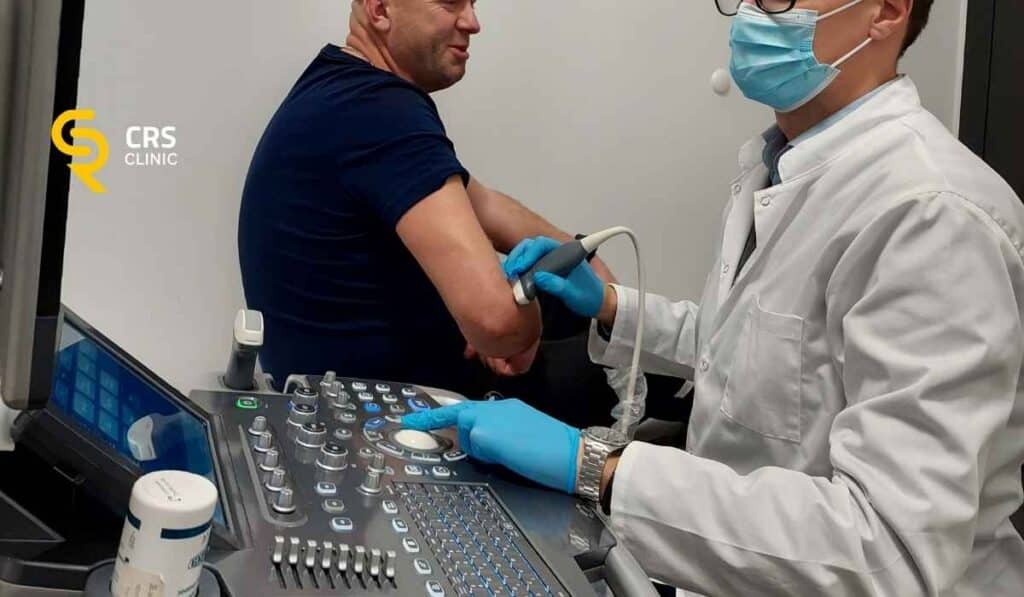 Lekarz ortopeda przeprowadza diagnostykę USG bólu łokcia u pacjenta w CRS Clinic Warszawa
