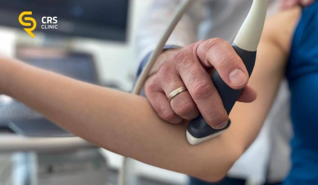 Lekarz ortopeda przeprowadza diagnostykę USG łokcia tenisisty u pacjentki w CRS Clinic Warszawa