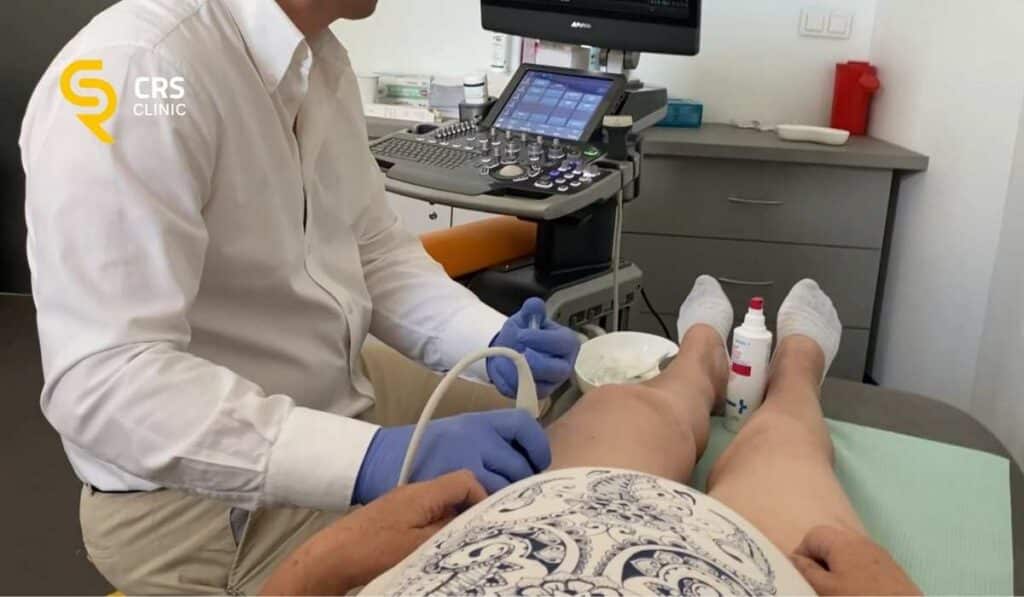 Lekarz ortopeda przeprowadza iniekcję pod kontrolą USG u pacjentki z zapaleniem kaletki krętarza w CRS Clinic