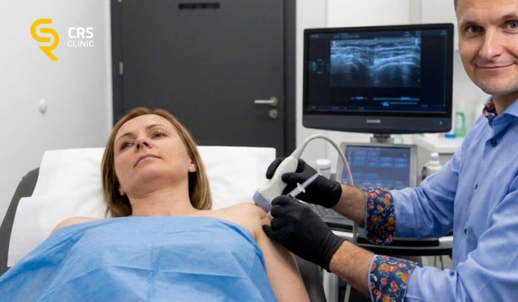 Lekarz ortopeda przeprowadza małoinwazyjny zabieg przeciwzapalny przy zamrożonym barku w CRS Clinic Warszawa