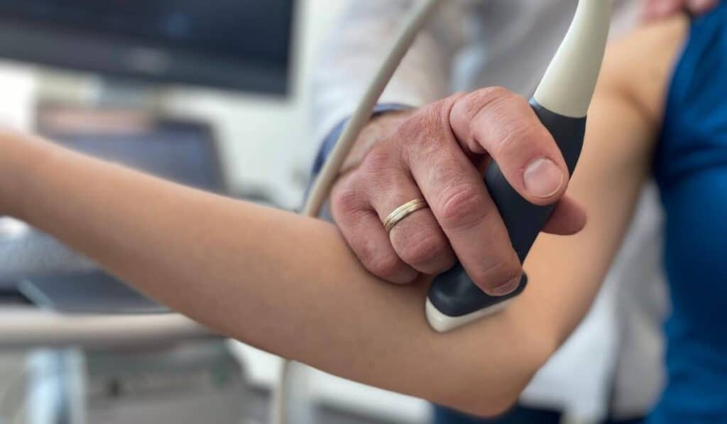 Lekarz ortopeda wykonuje badanie USG bólu łokcia u pacjenta w CRS Clinic Warszawa