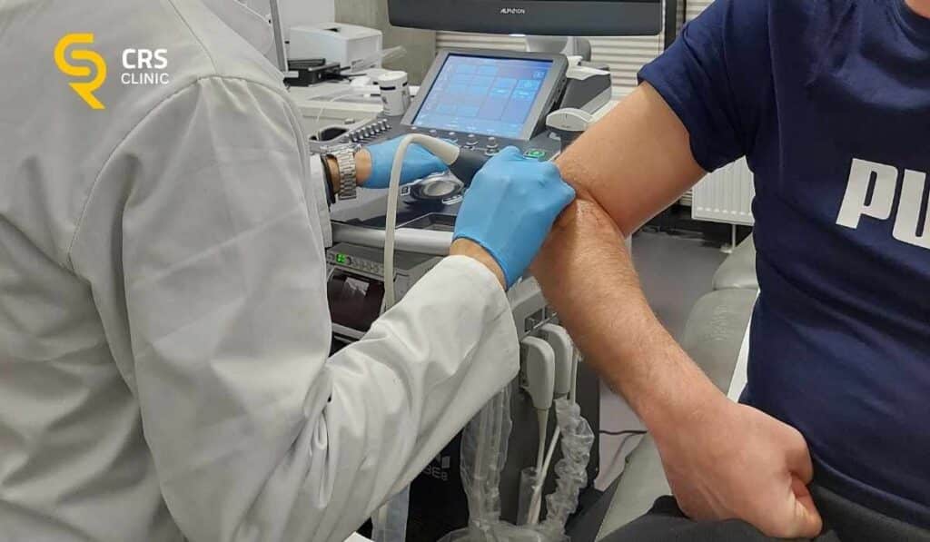 Lekarz ortopeda wykonuje badanie USG bólu łokcia u pacjentki z łokciem golfisty w CRS Clinic Warszawa