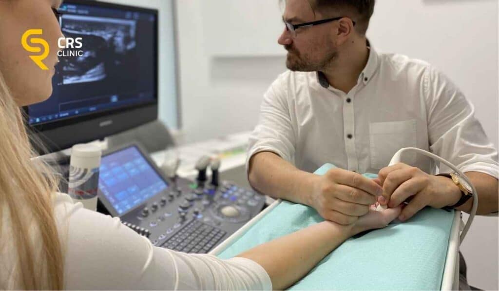 Lekarz ortopeda wykonuje badanie USG przed hydrodysekcją choroby de Quervaina w CRS Clinic Warszawa