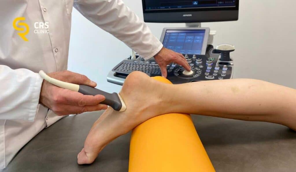 Lekarz ortopeda wykonuje badanie diagnostyczne USG przed rozpoczęciem leczenia ostrogi piętowej w CRS Clinic Warszawa