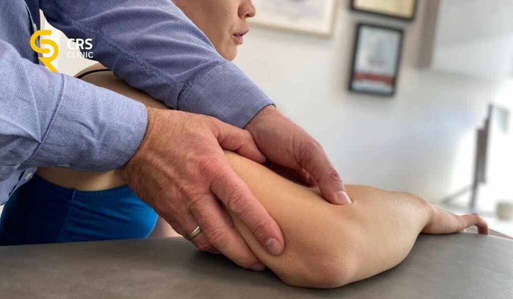 Lekarz ortopeda wykonuje badanie kliniczne bólu łokcia w CRS Clinic Warszawa