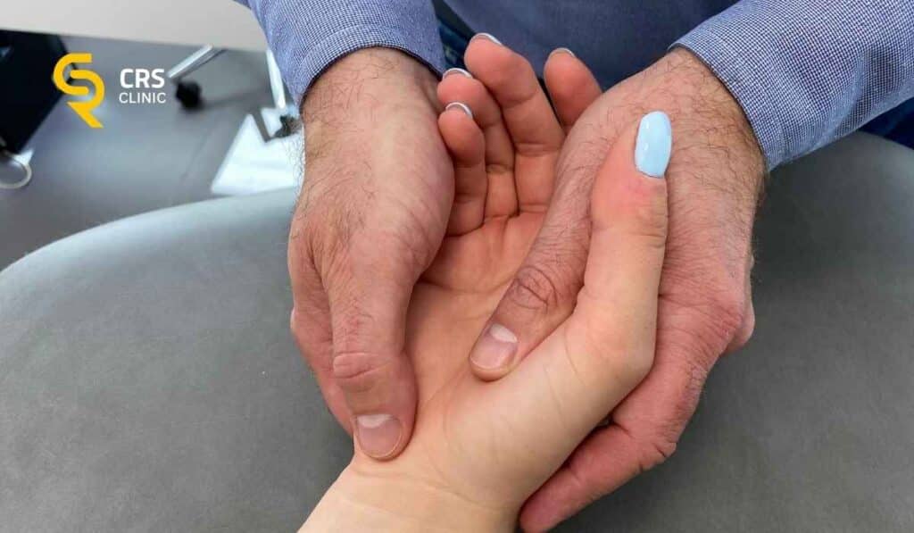 Lekarz ortopeda wykonuje badanie kliniczne kciuka w chorobie de Quervaina w CRS Clinic Warszawa