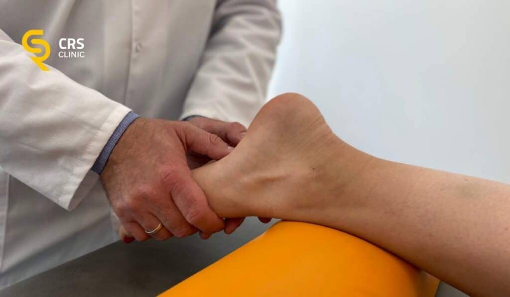 Lekarz ortopeda wykonuje badanie kliniczne u pacjentki z bólem pięty od spodu w CRS Clinic Warszawa