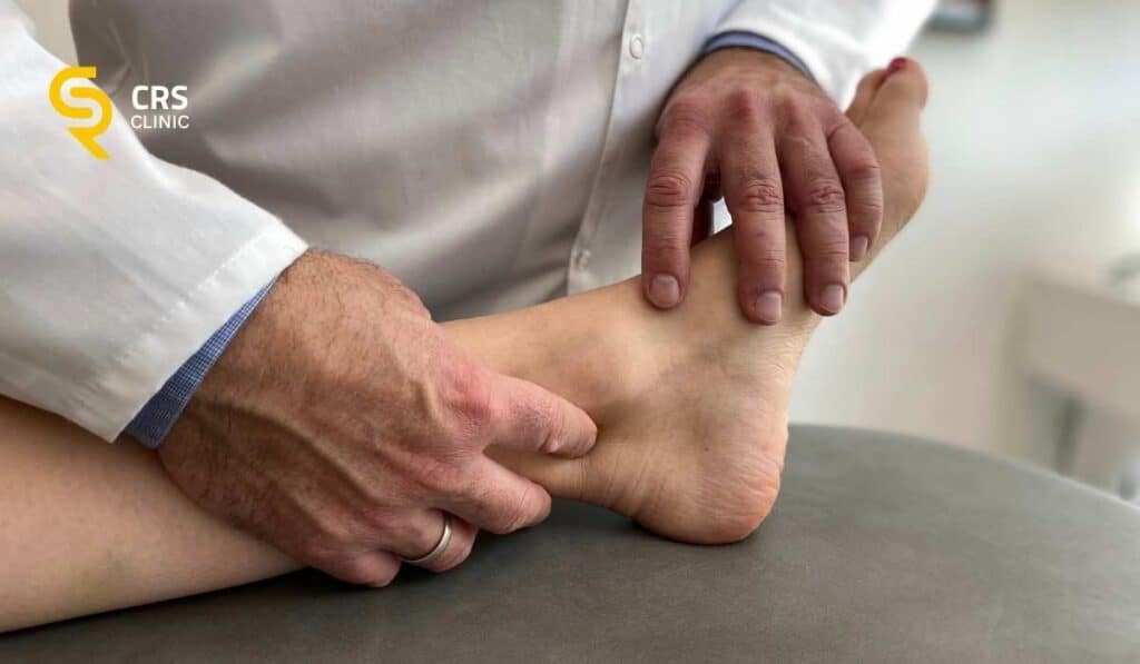 Lekarz ortopeda wykonuje badanie kliniczne u pacjentki z bólem z tyłu pięty w CRS Clinic Warszawa