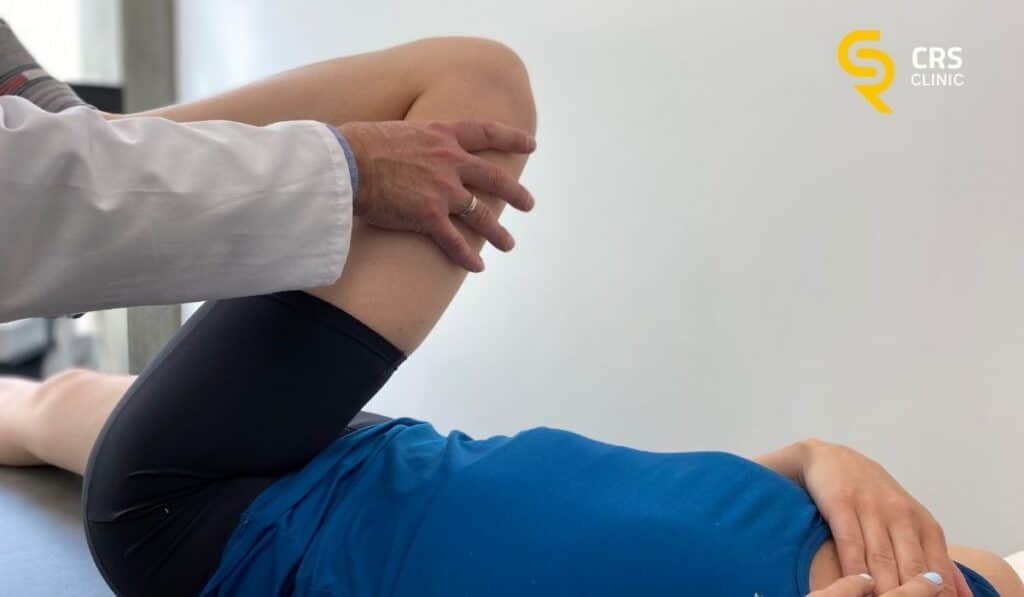 Lekarz ortopeda wykonuje badanie kliniczne u pacjentki z endoprotezą kolana w CRS Clinic Warszawa