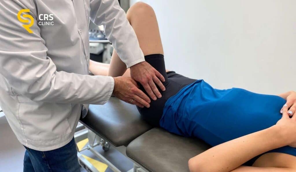 Lekarz ortopeda wykonuje badanie kliniczne u pacjentki z nocnym bólem biodra w CRS Clinic Warszawa