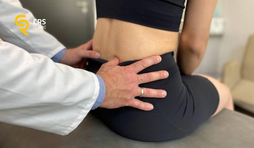 Lekarz ortopeda wykonuje badanie kliniczne u pacjentki z rwą kulszową w CRS Clinic Warszawa