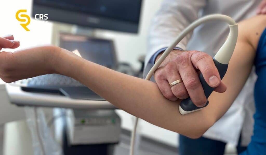 Lekarz ortopeda wykonuje diagnostykę i badanie USG łokcia u pacjentki z łokciem golfisty w CRS Clinic Warszawa