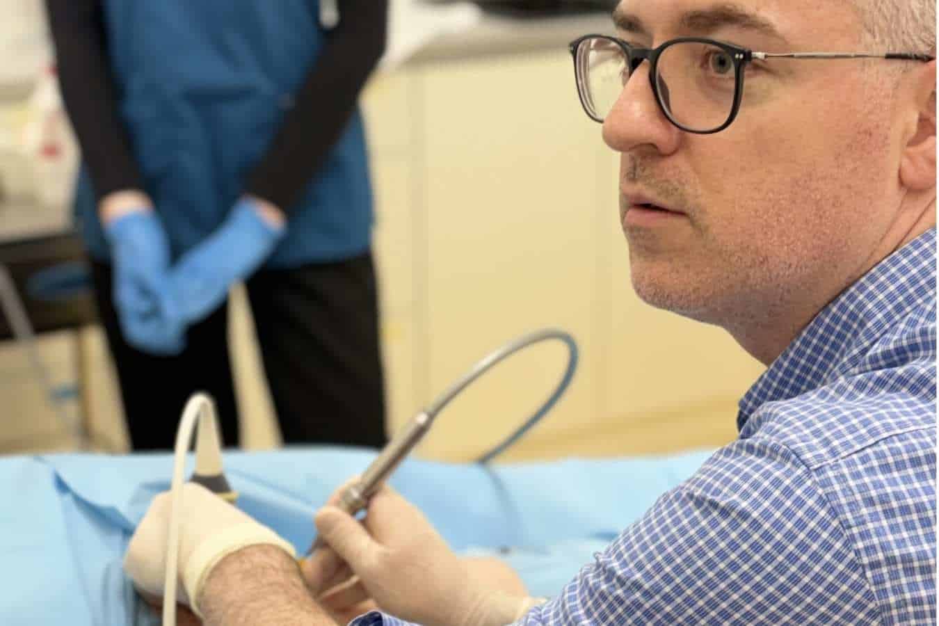 Lekarz ortopeda wykonuje zabieg kriolezji u pacjenta w oczekiwaniu na operację na NFZ w CRS Clinic Warszawa
