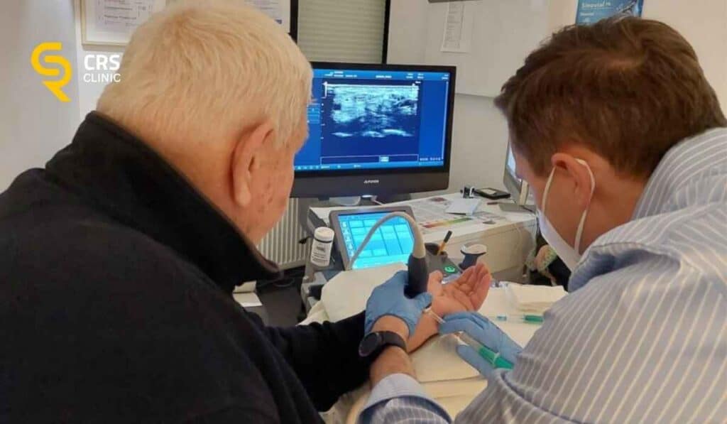 Lekarz ortopeda wykonuje zastrzyk sterydowy pod kontrolą USG w leczeniu choroby de Quervaina w CRS Clinic Warszawa