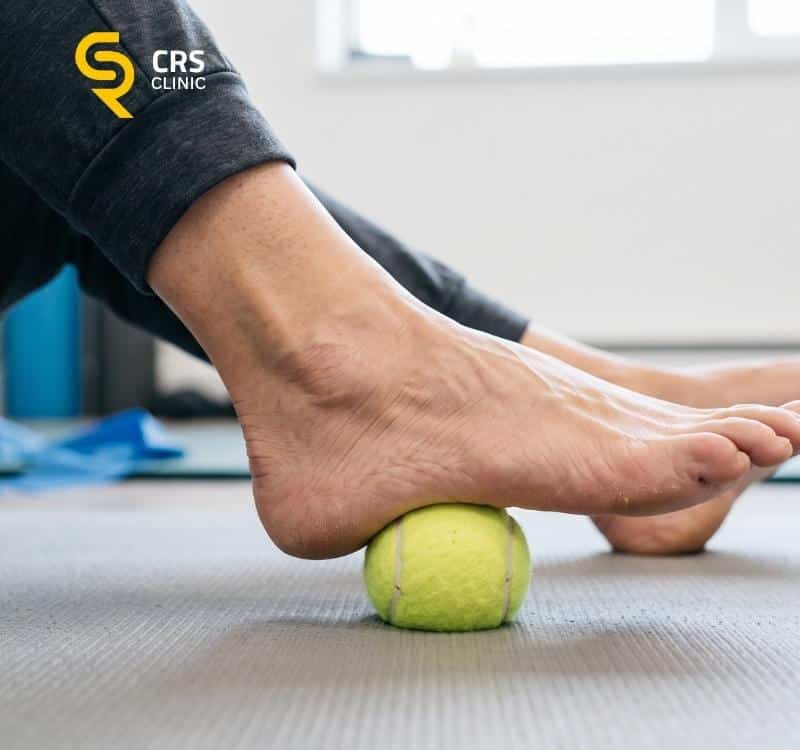 Pacjent z ostrogą piętową wykonuje ćwiczenia wzmacniające rozcięgno piętowe w CRS Clinic Warszawa