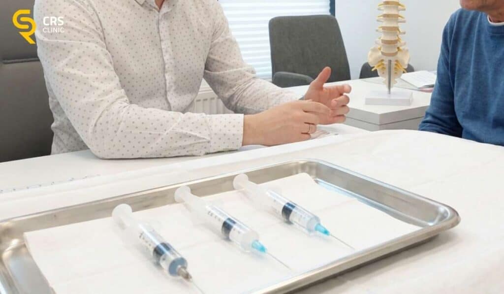 Lekarz neurochirurg wyjaśnia pacjentowi różnicę między różnymi blokadami na rwę kulszową w CRS Clinic Warszawa