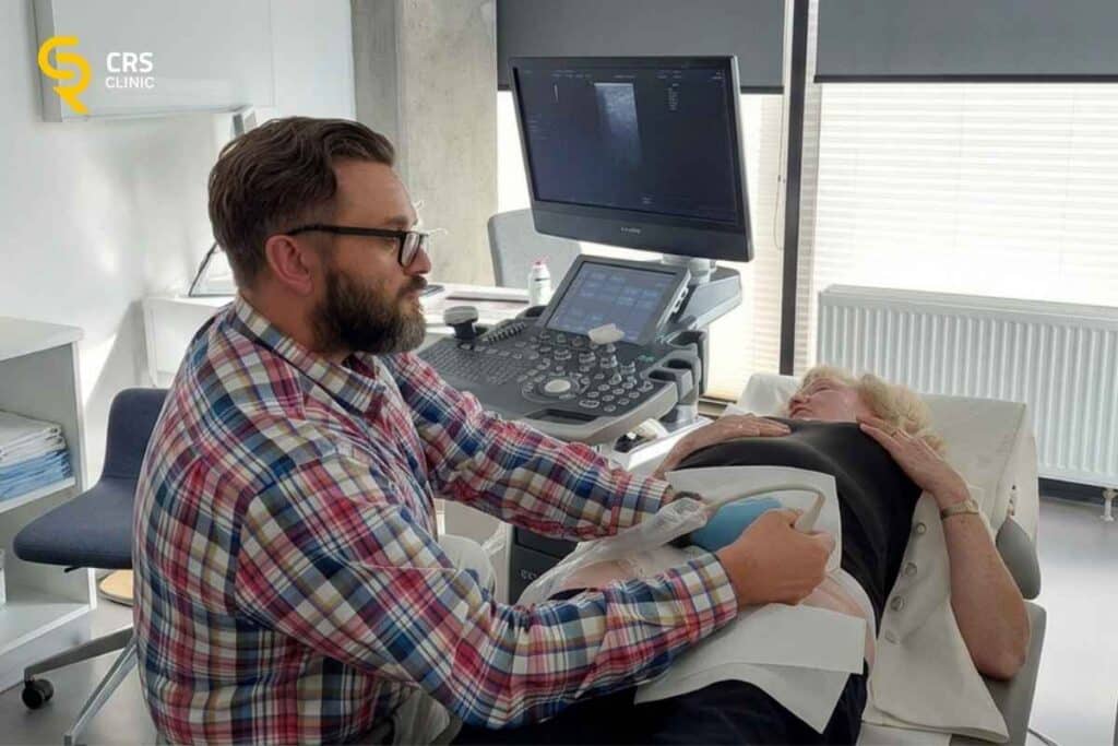 Lekarz ortopeda przeprowadza diagnostykę USG u pacjentki przed podaniem kwasu hialuronowego do stawu w CRS Clinic Warszawa
