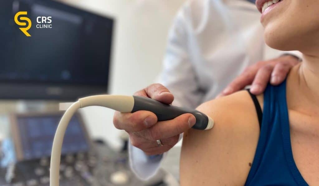 Lekarz ortopeda wykonuje badanie USG u pacjentki z podejrzeniem uszkodzenia stożka rotatorów w CRS Clinic Warszawa