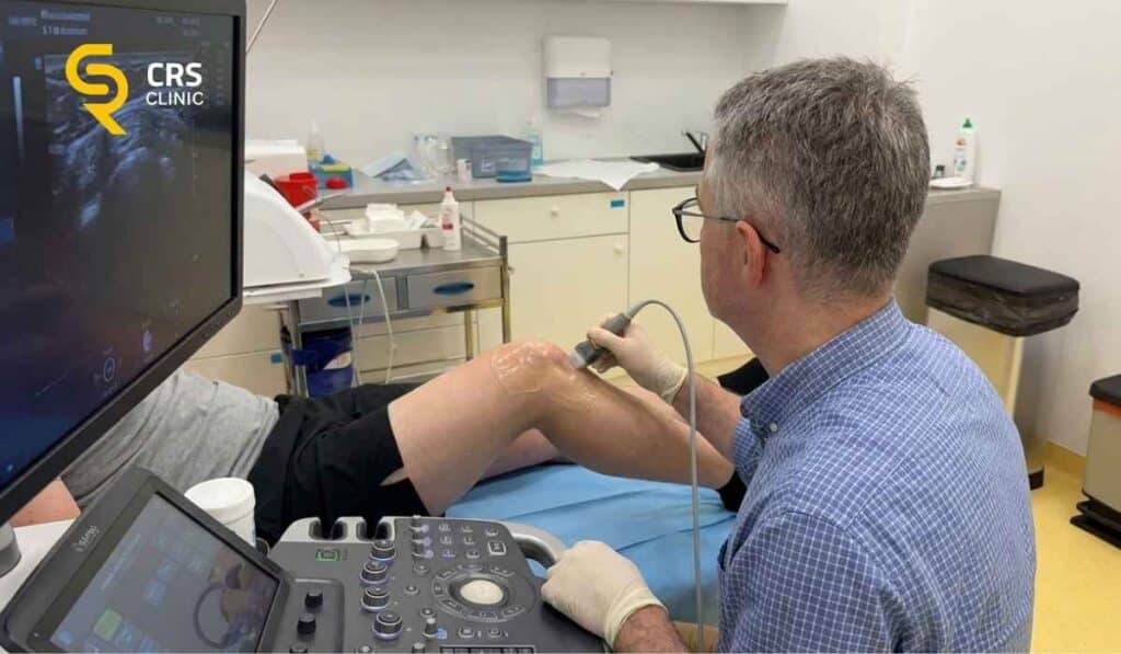 Lekarz ortopeda wykonuje diagnostykę ultrasonograficzną u pacjenta z torbielem Bakera w CRS Clinic Warszawa