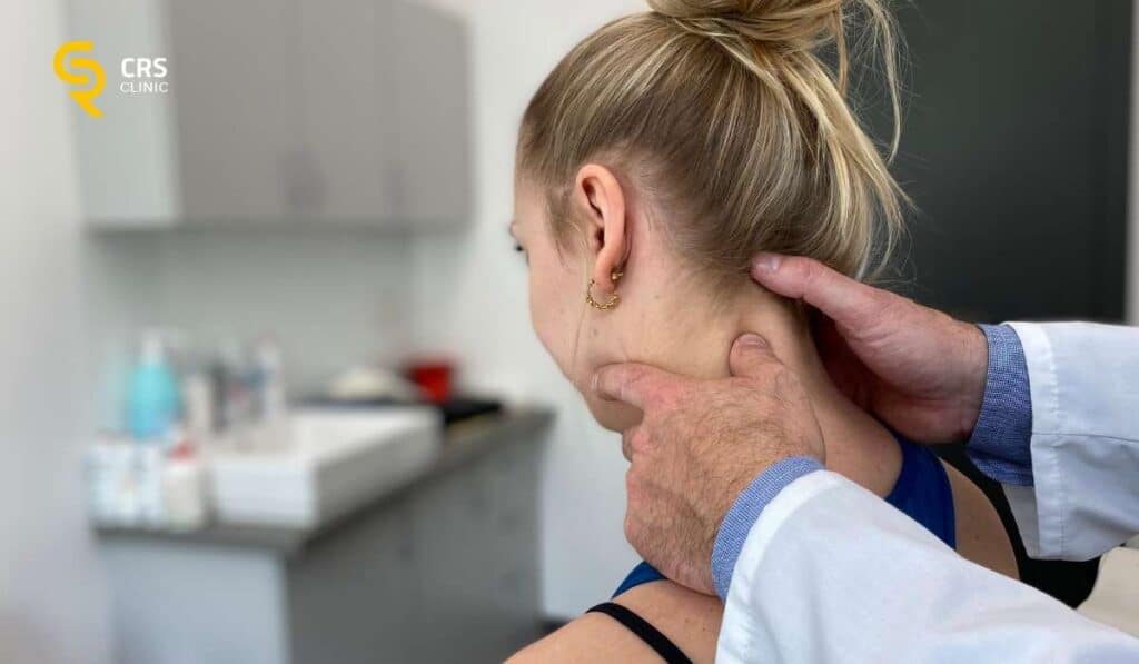 Lekarz neurochirurg wykonuje badanie kliniczne u pacjentki z bólem szyi przy rwie barkowej w CRS Clinic Warszawa