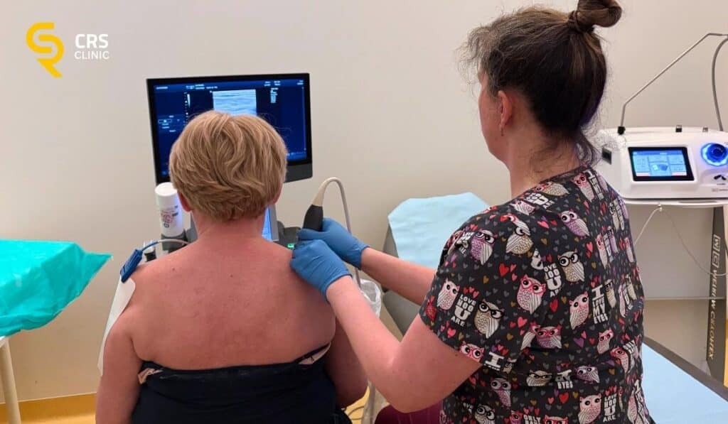 Lekarz ortopeda przeprowadza diagnostykę USG u pacjenta z bólem barku w CRS Clinic Warszawa